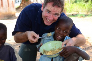 David Morrison assisting boy with food