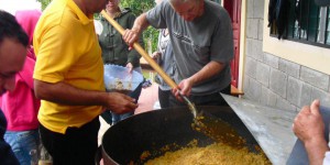 giant pot full of beans and rice being served to people