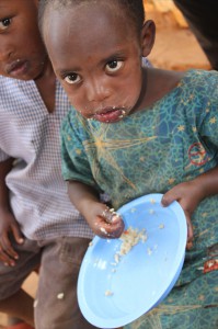 little kid with food on her face and fingers