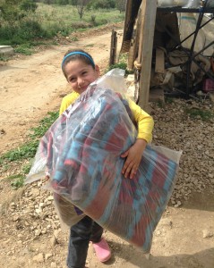 little girl caring bag of blankets
