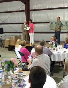 Jackie Walorski presenting Pastor Steve Sumrall a reward at warehouse opening