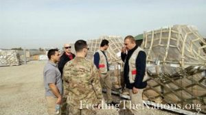 Men talking next to a food supply drop