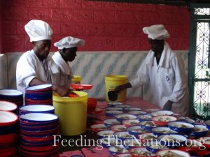 3 men filling up bowls with beans and rice