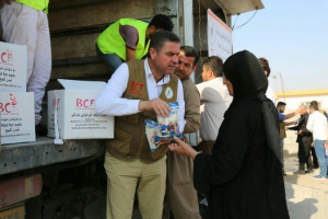 man giving food to Syrian Woman